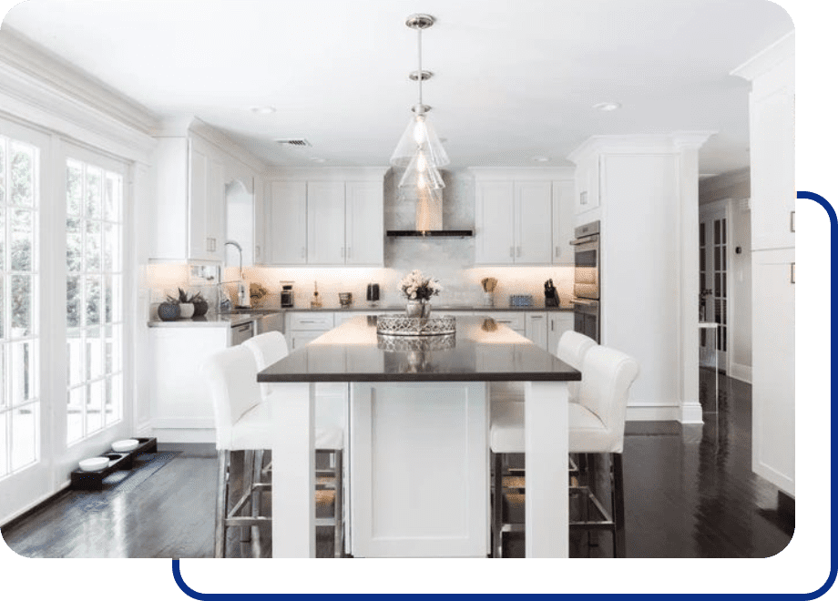 Modern white kitchen with island and chairs.