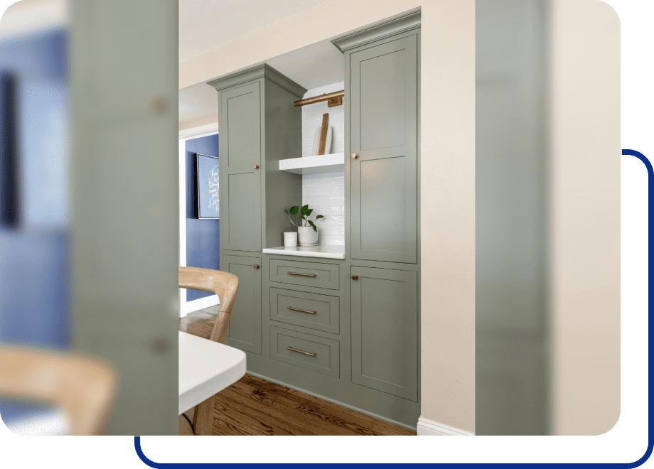 Green kitchen cabinets with wooden floor.